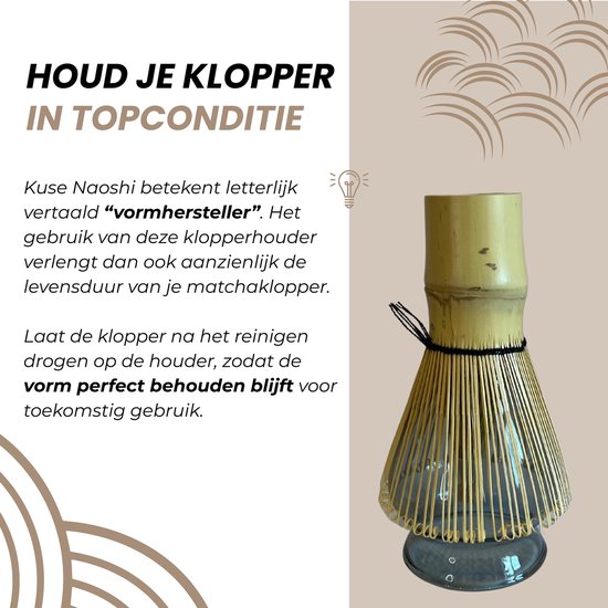 Bamboe matcha klopper in een grijze glazen houder. De houder is kelkvormig en breed aan de voet.