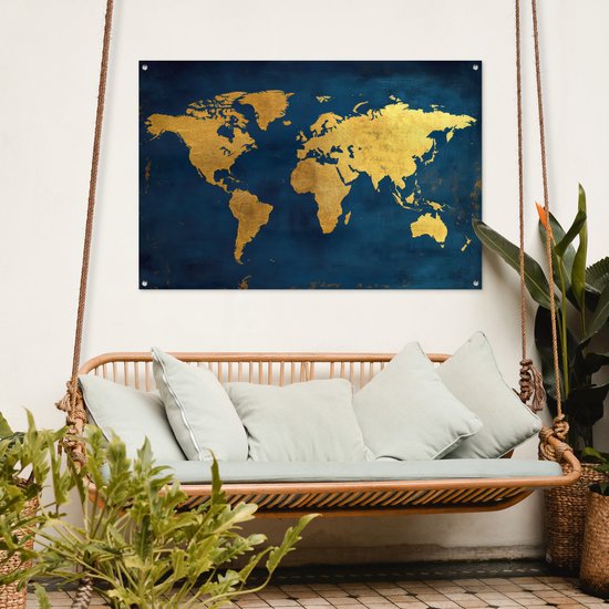 Carte du monde dorée sur fond bleu foncé, suspendue au-dessus d'une balançoire en rotin avec des coussins.