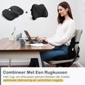 Een vrouw zit achter een bureau met een laptop, met een zwart zitkussen en rugkussen op de stoel.