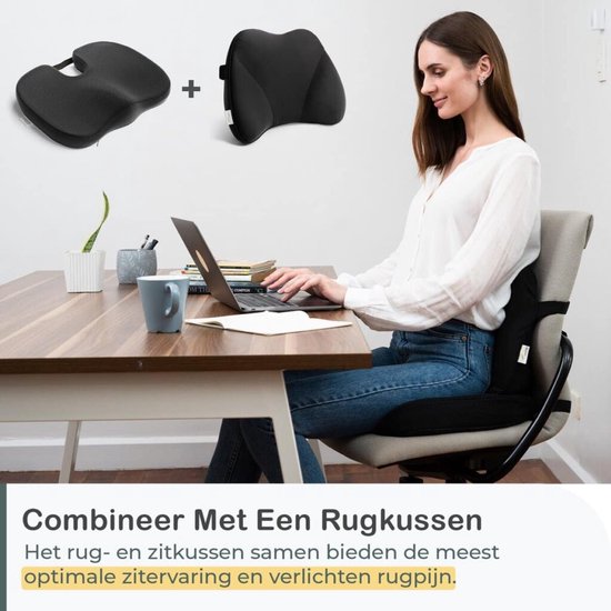 Een vrouw zit achter een bureau met een laptop, met een zwart zitkussen en rugkussen op de stoel.