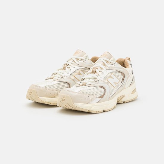 Paar beige New Balance 530 sneakers met beige zolen.