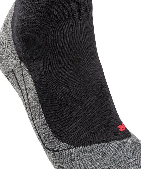 Grijze, geribbelde zone op de wreef van een zwarte sportsok met FALKE logo.