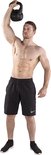 Een gespierde man met zwarte sportbroek en zwarte schoenen tilt een 8 kg zwarte kettlebell boven zijn hoofd.