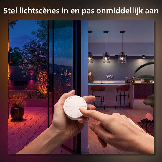 Een hand bedient een Hue Tap Dial Switch, met uitzicht op een tuin en woonkamer met verschillende verlichtingsscènes.