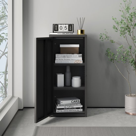 Zwarte metalen kast, met open deur, gevuld met boeken en decoratie.
