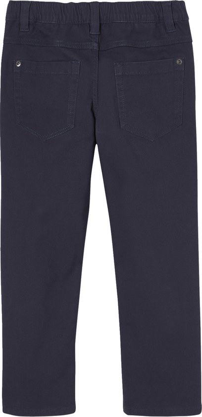Jongetje in donkerblauwe winterjas met lichtgroen, grijze muts, donkerblauwe broek en schoenen.