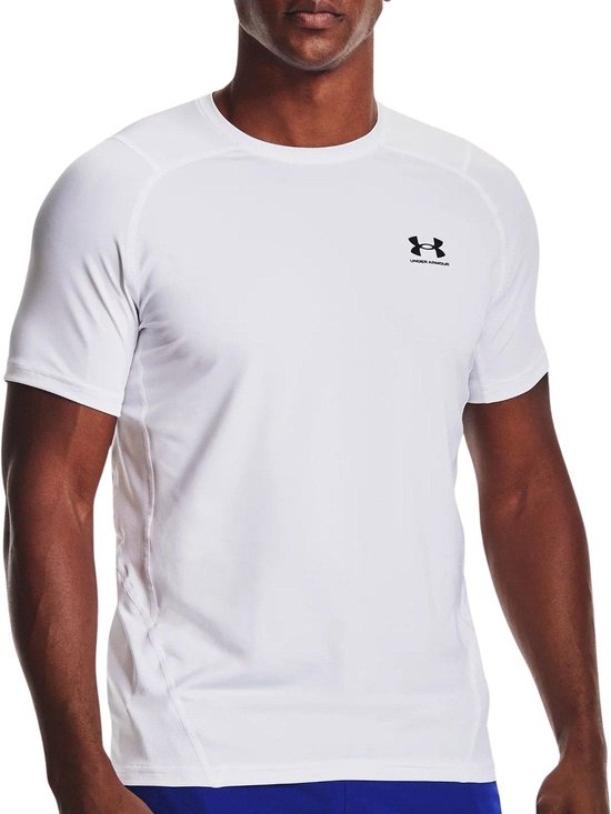 Man met witte Under Armour sportshirt en blauwe sportbroek. Zwart Under Armour logo op de borst.