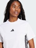 Model met gevlochten haar, draagt een wit t-shirt met een zwart Adidas logo.