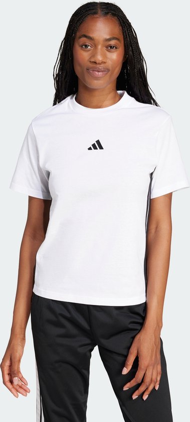 Model staat frontaal, draagt een wit t-shirt met zwart Adidas logo en sportbroek met strepen.