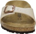 Birkenstock slipper in parelmoer wit met kurken zool en koperkleurige gesp.
