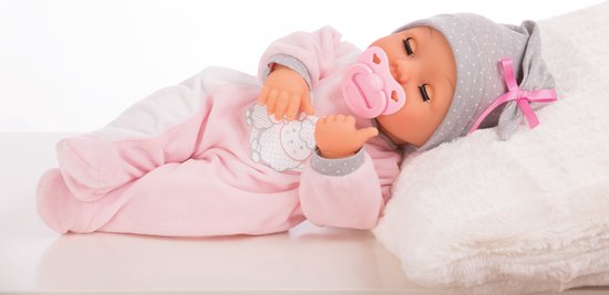 Slapende babypop in roze slaappakje met grijze stippenmuts, liggend op een kussen.