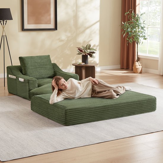 Groene corduroy fauteuil met uitklapbaar bed, met een vrouw die rust.