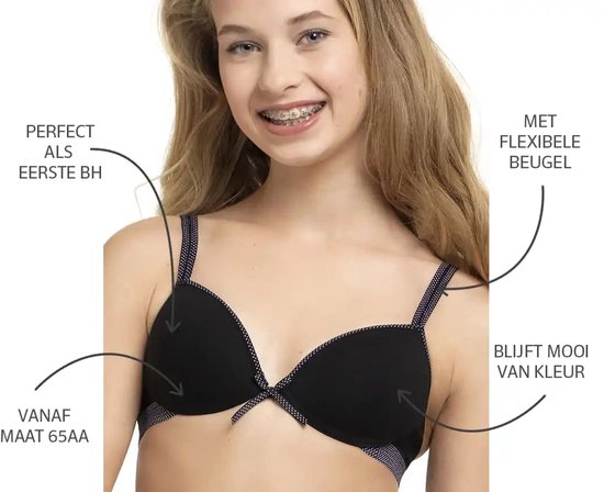 Jong meisje met beugel-bh in zwart met stippenrand en strikje. Tekst: 'Perfect als eerste BH', 'Vanaf maat 65AA', 'Met flexibele beugel', 'Blijft mooi van kleur'.