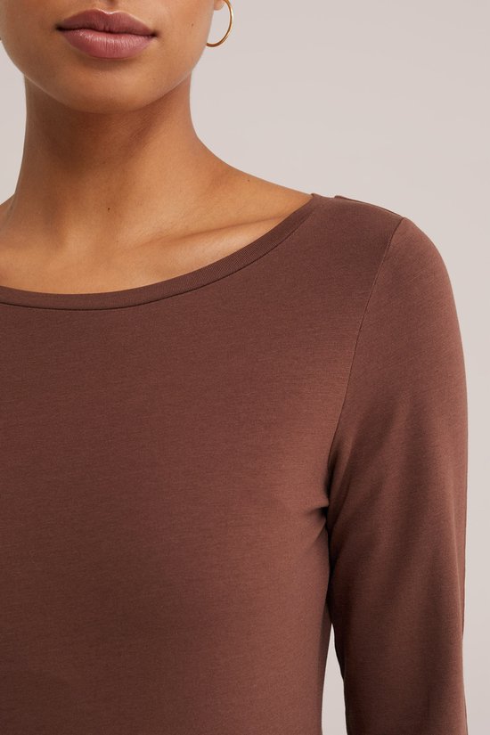 Close-up van een bruin T-shirt met driekwart mouwen en boothals.