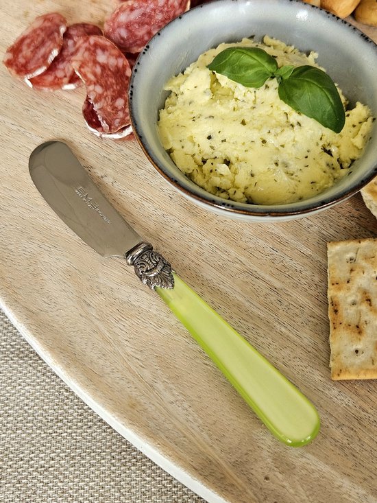 Boterermes met limoengroene steel en zilverkleurige versiering, naast salami en crackers.