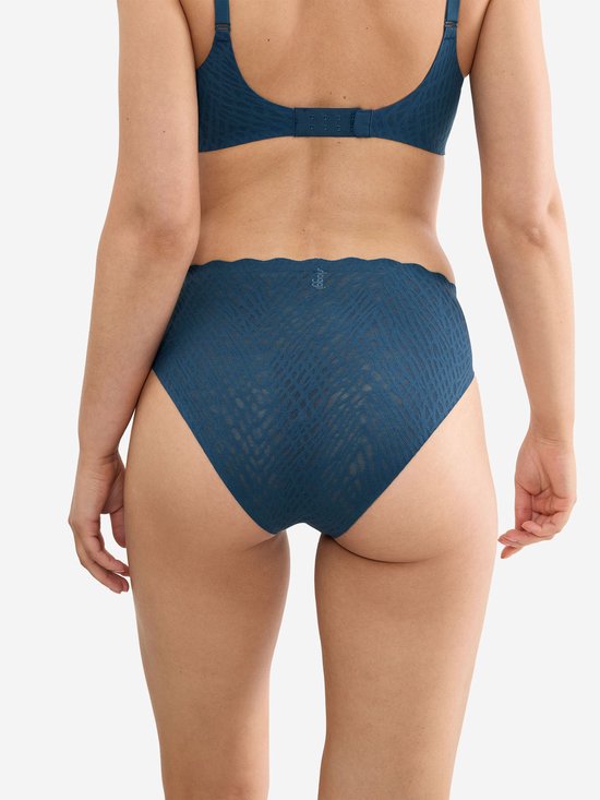 Model draagt donkerblauwe slip met golfvormige rand en visgraatpatroon.