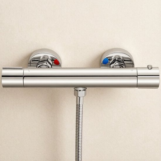 Douchethermostaat aan de muur gemonteerd met rode en blauwe knoppen voor temperatuur, metalen slang.