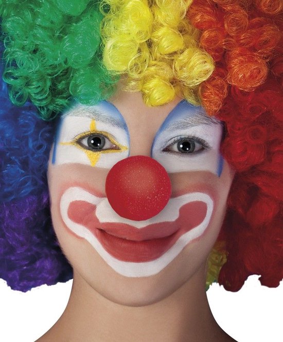 Een clown met een felgekleurde pruik in regenboogkleuren en rood-witte schmink met een rode neus.