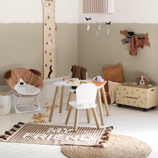 Kindertafel met twee stoelen in een speelkamer. Witte tafel en stoelen met houten poten.