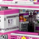 Close-up van interieur van roze bouwsteen foodtruck met keukenapparatuur zoals een mixer, deegroller en aanrecht.