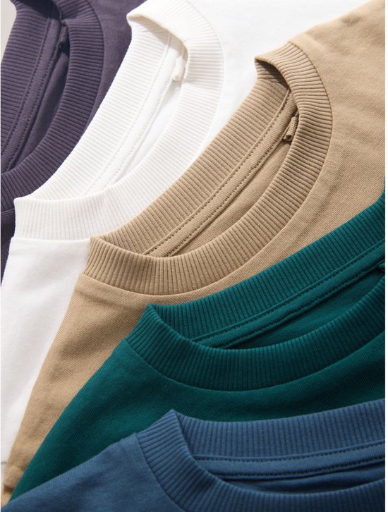 Close-up van de kragen van vijf gestapelde T-shirts in donkergrijs, wit, beige, groen en blauw.