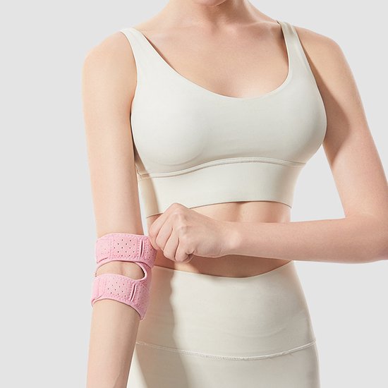 Roze elleboogbrace met klittenbandsluiting, gedragen door een vrouw in sportkleding.