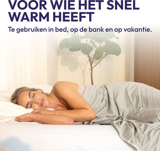 Een vrouw slaapt onder een grijs dekbed, ideaal voor wie het snel warm heeft.