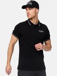 Man met zwarte Lonsdale pet en zwart poloshirt met witte strepen op kraag en mouwen. Lonsdale London logo.