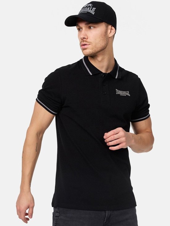 Man met zwarte Lonsdale pet en zwart poloshirt met witte strepen op kraag en mouwen. Lonsdale London logo.