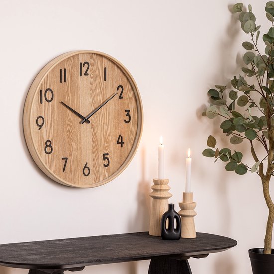 Ronde beige houten wandklok met zwarte cijfers en wijzers. Houten kast.