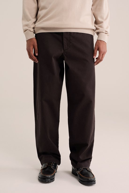 Man in beige coltrui en bruine chino.