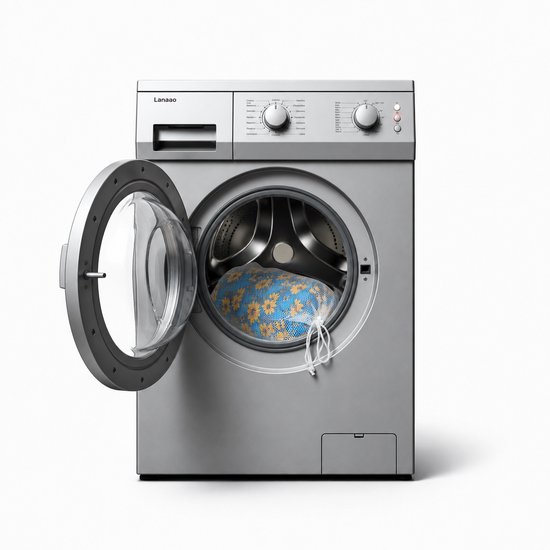 Kussen met bloemenprint in een wasnet in een open wasmachine.
