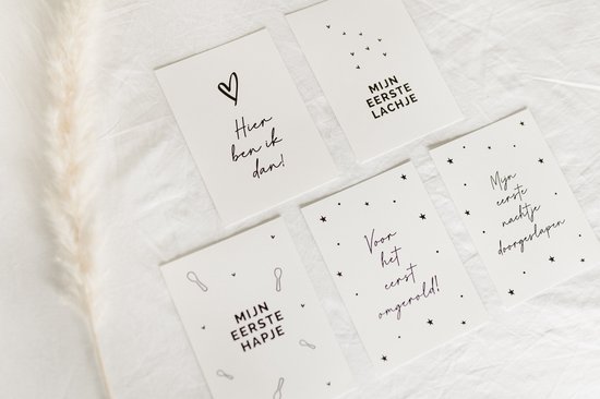 Baby mijlpaalkaarten met de tekst 'Hier ben ik dan!', 'Mijn eerste lachje', 'Voor het eerst omgerold!', 'Mijn eerste hapje', 'Mijn eerste nachtje doorgeslapen.'