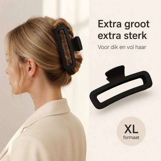 Grote, zwarte haarklem met XL formaat, getoond in het opgestoken blonde haar van een vrouw.