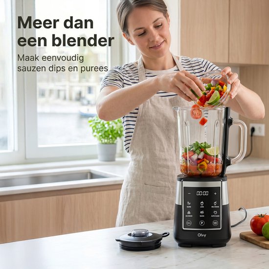 Vrouw doet groenten in de glazen kan van een zwarte en zilveren blender.