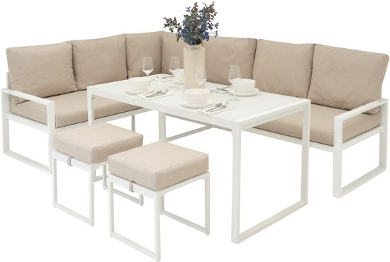 Wit L-vormig tuinbank met beige kussens, een witte tafel en twee krukken.