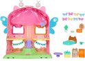 Roze Fairylandia speelhuis met accessoires, waaronder een bed, tafel en koelkast.