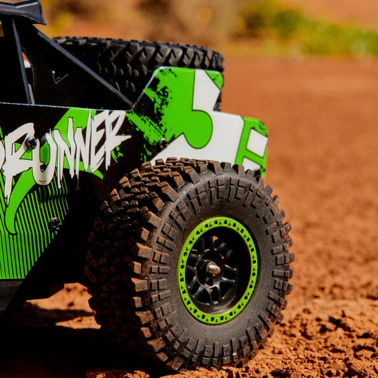 Close-up van de achterkant van een groene en witte RC-auto "Acid Runner" op stoffig terrein.