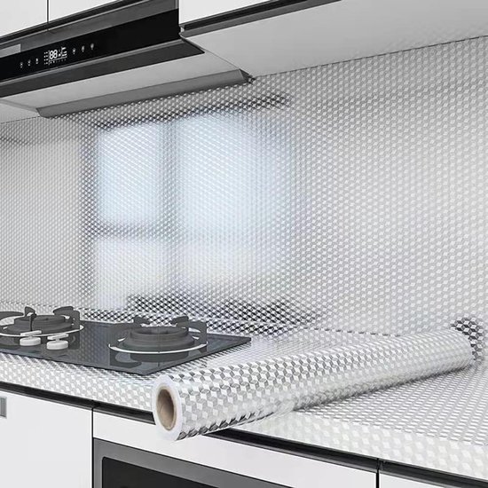 Zilveren aluminiumfolie met ruitpatroon op keukenachterwand en aanrecht, met een rol folie.