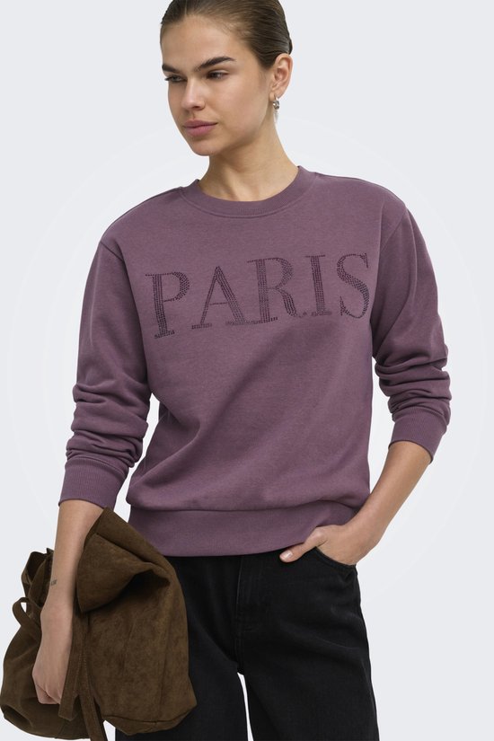 Paarse sweater met "PARIS" belettering van steentjes, gedragen door model.