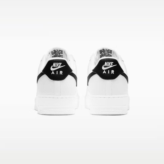 Achterkant van twee witte Nike Air Force 1 sneakers met zwarte 'NIKE AIR' logo's.