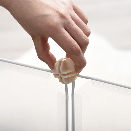 Hand plaatst een beige connector op witte stangen, die witte kunststof panelen verbinden.