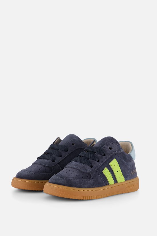 Baskets bleu foncé en suède avec des rayures jaune fluo, des lacets et une semelle marron.