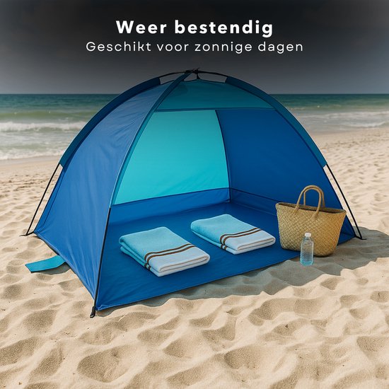 Een blauwe strandtent met gestreepte handdoeken en een waterfles op het zand.
