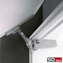 Detail van een metalen scharnier aan de binnenkant van een witte kastdeur.