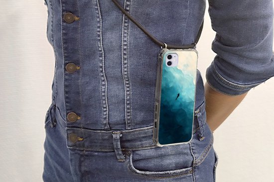 Coque pour iPhone 12 Mini avec paysage marin abstrait et plongeur en nuances de bleu, portée en bandoulière.
