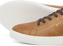 Close-up van bruine leren sneakers van Jack & Jones met witte zolen en goudkleurig logo.