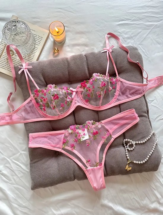 Roze kanten lingerieset met bloemenpatroon, gedetailleerd met strikjes en parelketting.