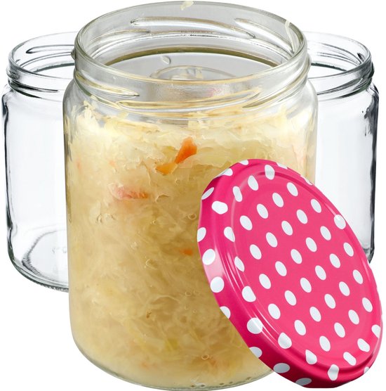 Glazen weckpot gevuld met zuurkool, naast lege potten, met roze deksel met witte stippen.