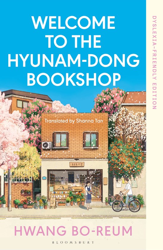 Boekcover 'Welcome to the Hyunam-dong Bookshop' met een tekening van een boekwinkel in de lente, met bloeiende bomen. Nederlands, Frans, dyslexie-vriendelijke editie.